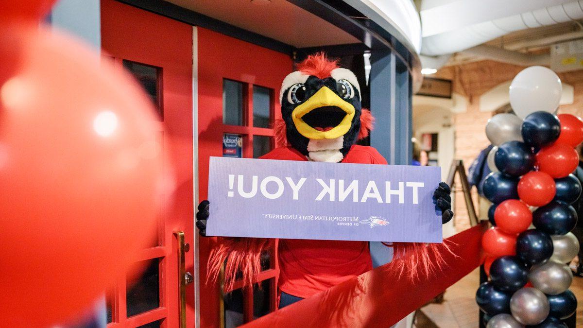 Rowdy holding a Thank You sign in front of 粗暴的角落 at the grand opening in November 2022.